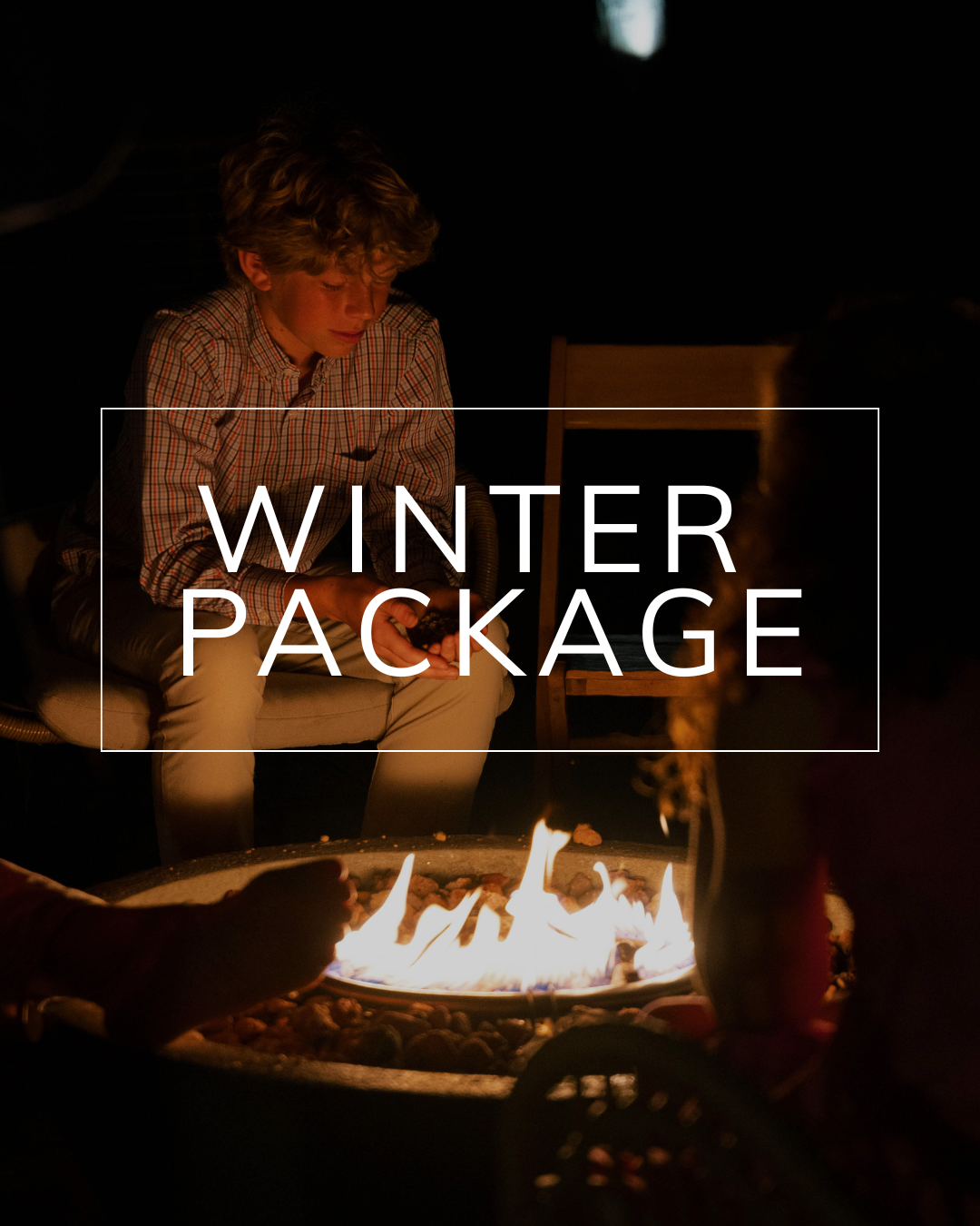 A person sits by a glowing outdoor fire pit at night with the text