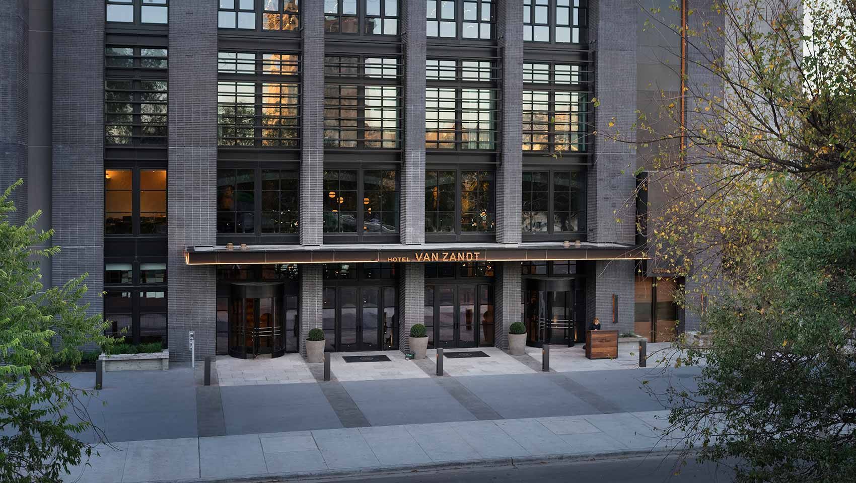 A grey building with an awning over the front doors. 