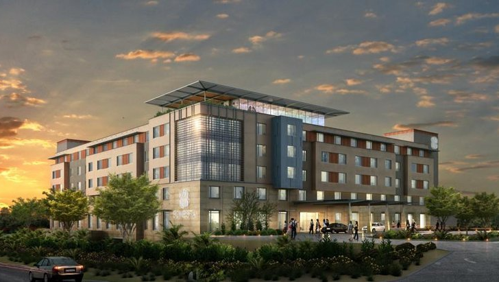An artist 's impression of a large building with a sunset in the background.