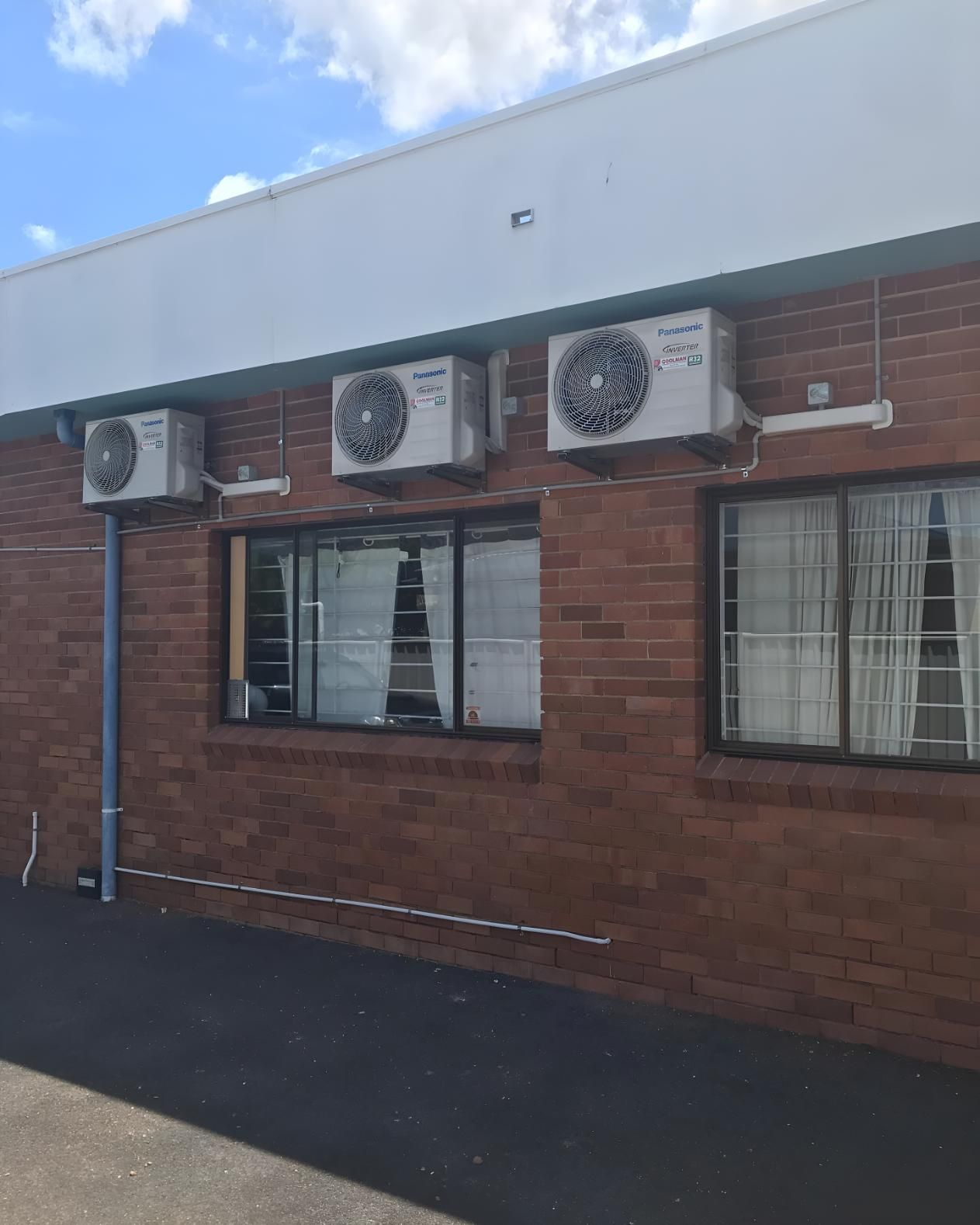 Brick Building With Three Air Conditioners — Coolman Airconditioning in Broken Head, NSW