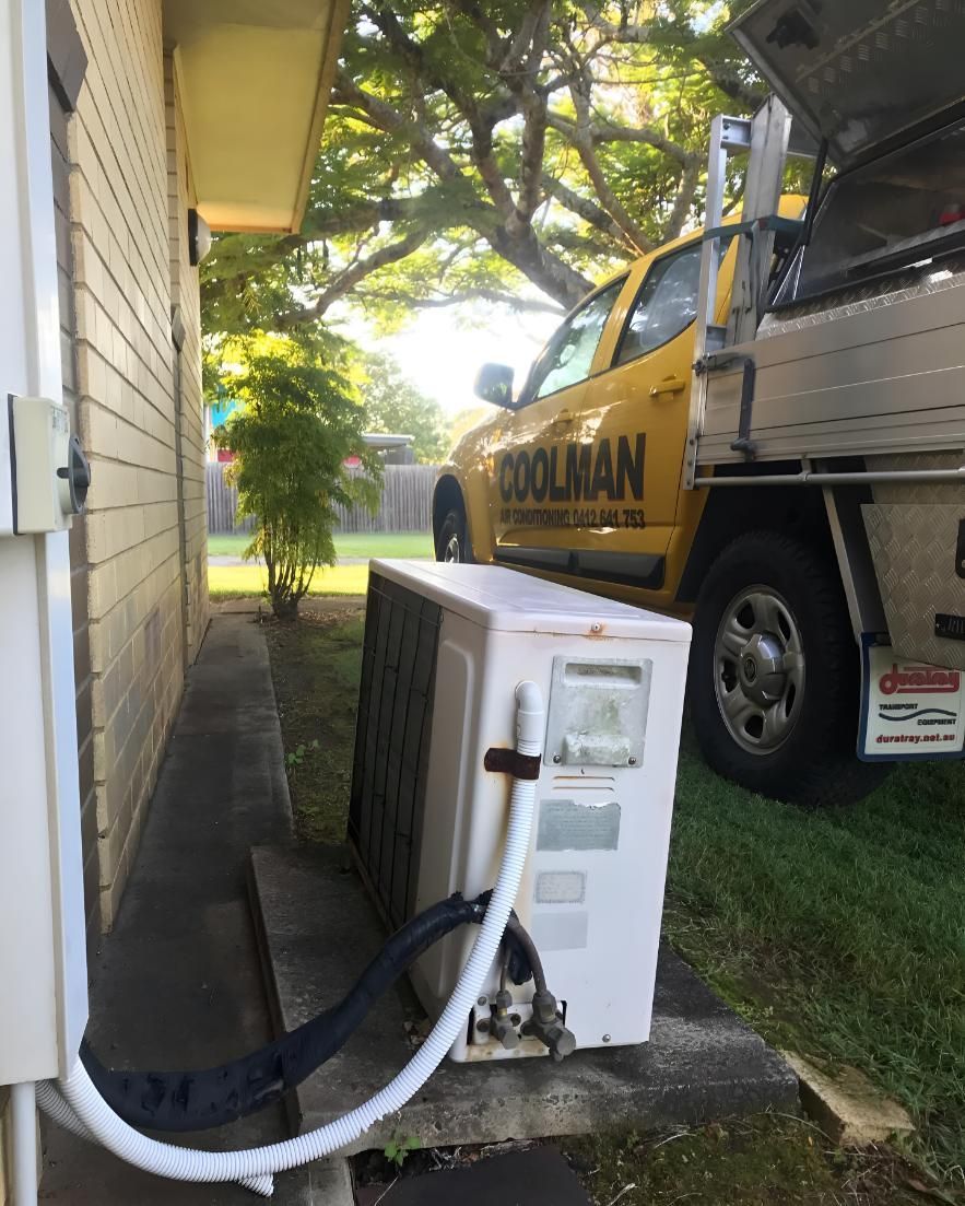 Yellow Truck is Parked on the Side of a Building — Coolman Airconditioning in Broken Head, NSW