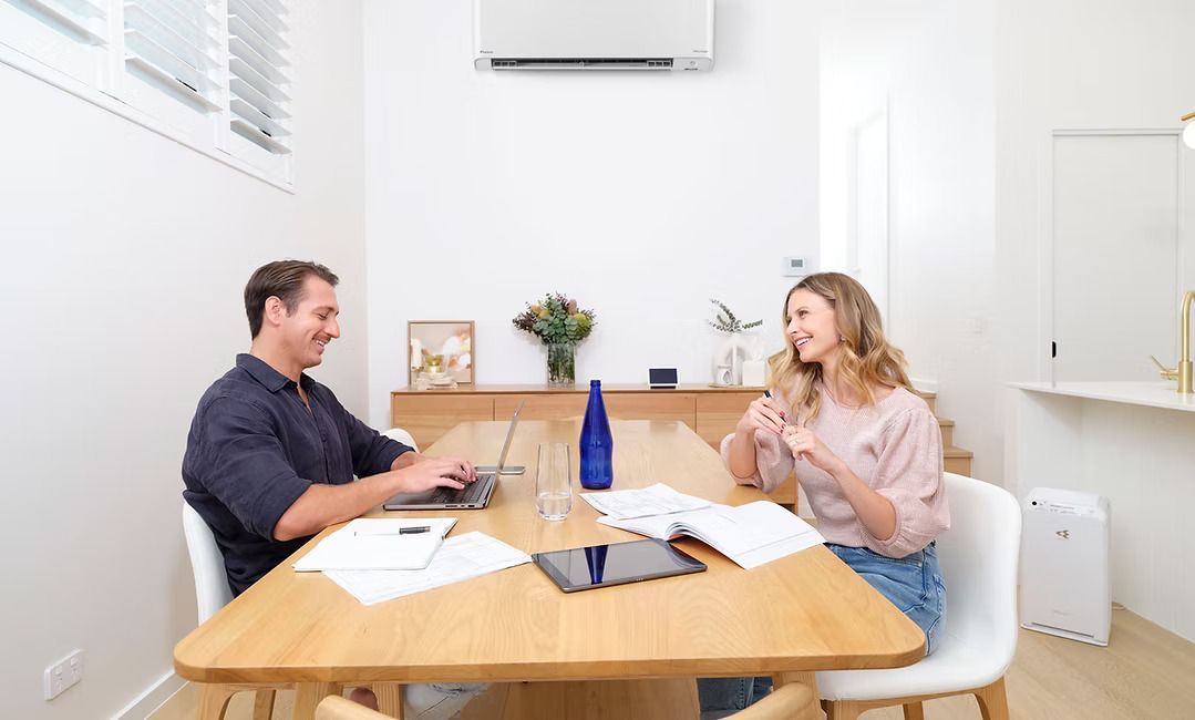 Couple sitting in living room with air conditioner