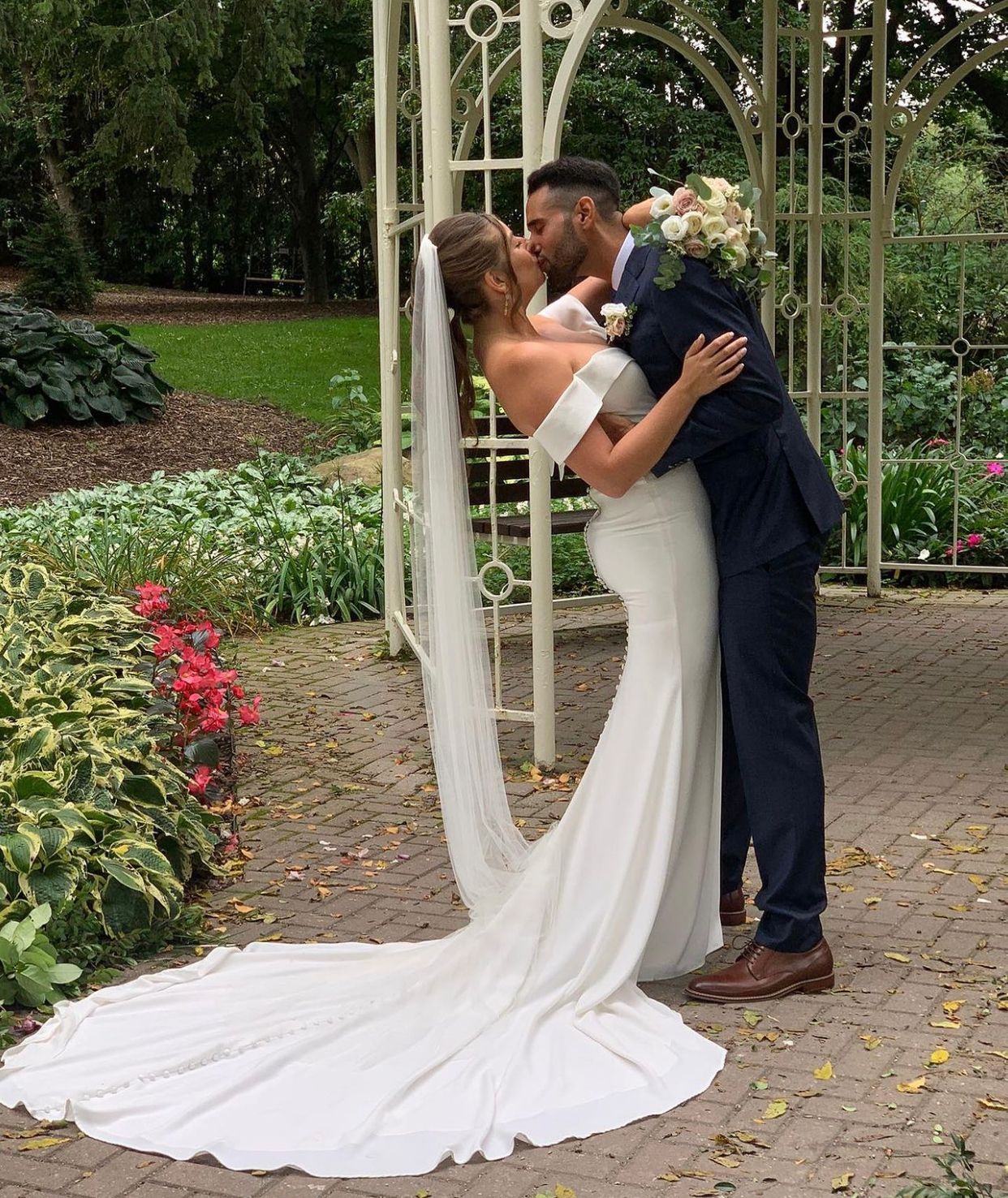 Bride and groom with a wedding floral arrangement
