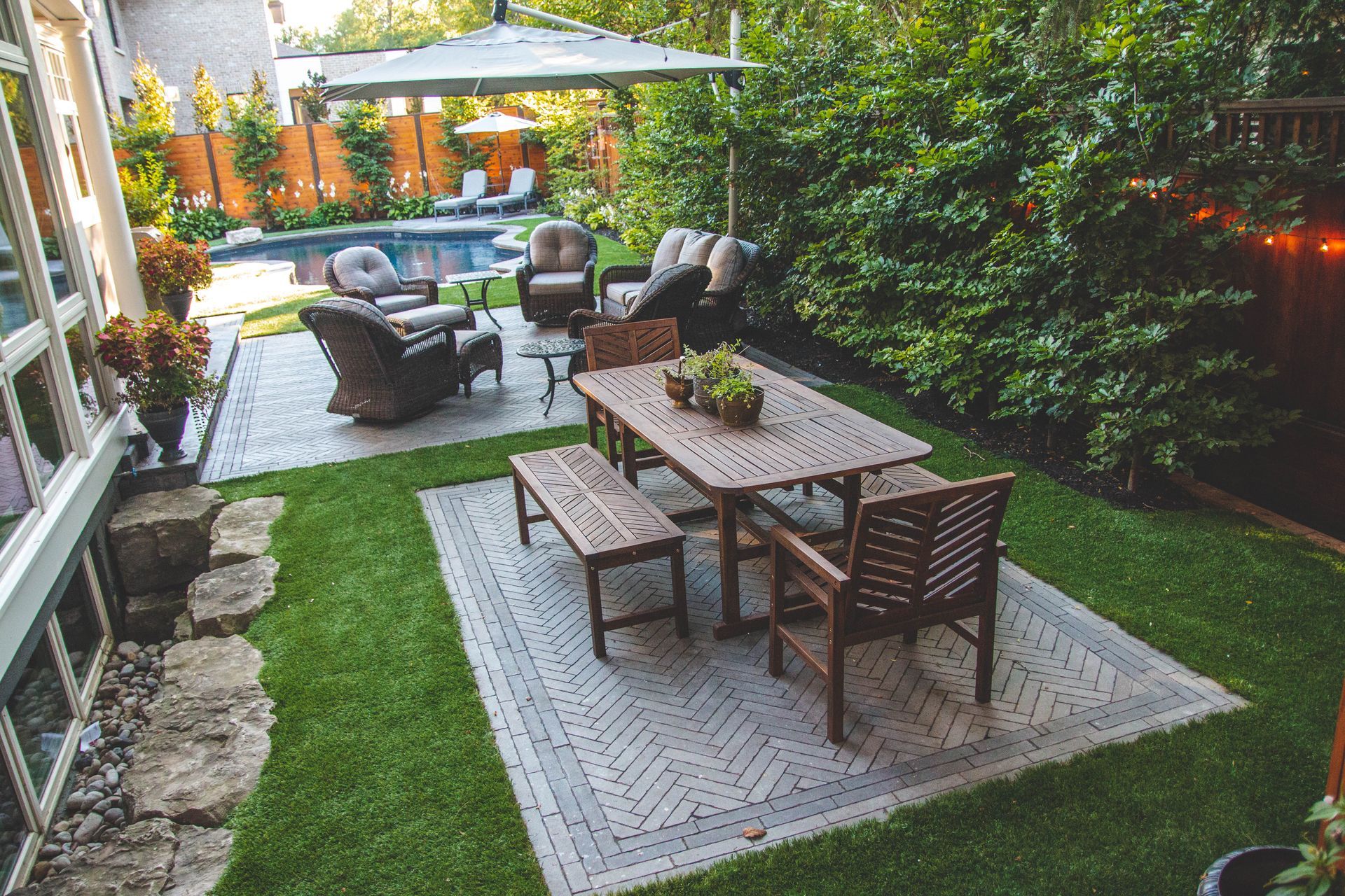 There is a table and chairs in the middle of the backyard.