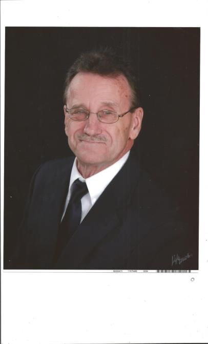 A man in a suit and tie is smiling for the camera