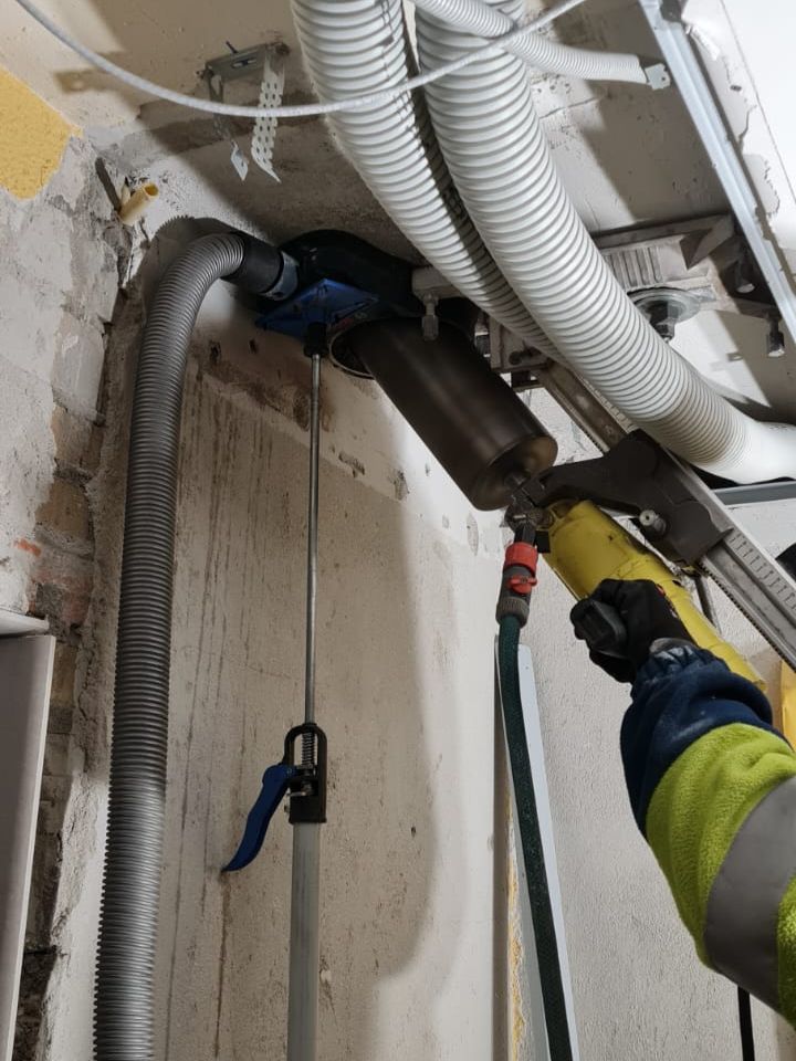 Gat boren van onder naar boven door beton plafond voor ventilatie en riolering buis