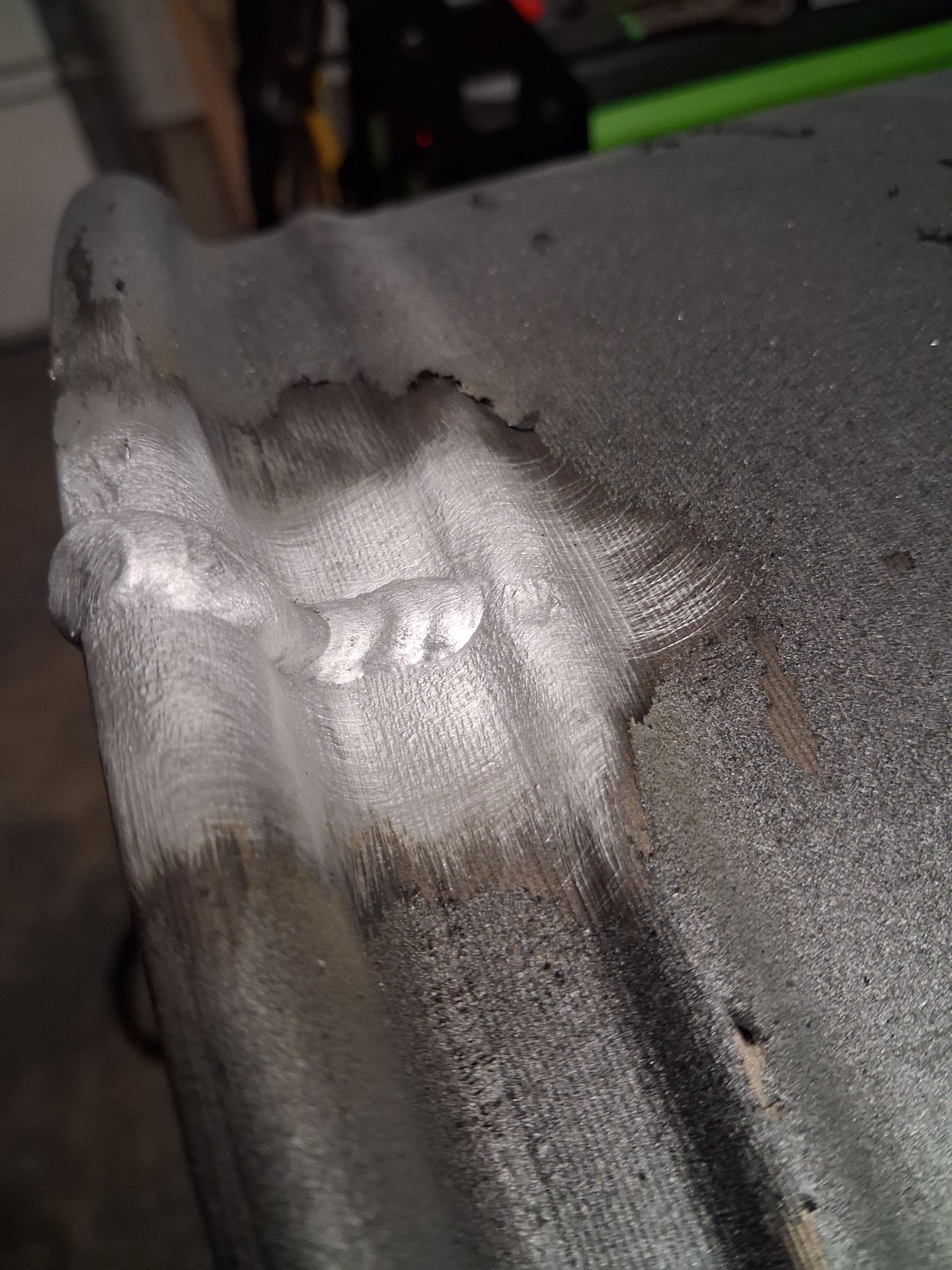 White powdery residue on a gray textured surface with dark streaks nearby