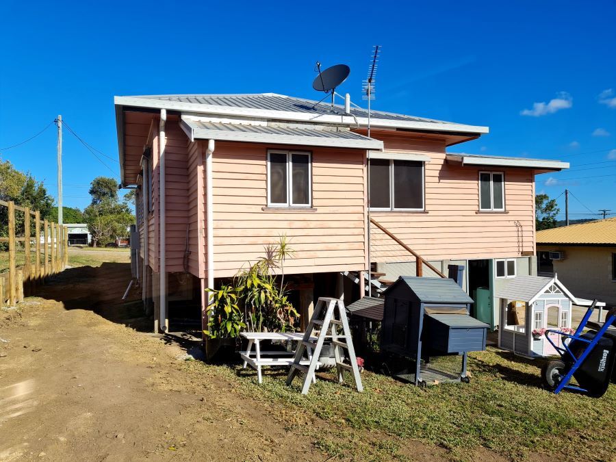 A Pink House With a Ladder and a Chicken Coop in Front of It — Pro-Jax Pty Ltd in Mount Isa, QLD