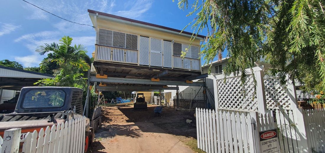 A House With a White Picket Fence and a Truck Parked in Front of It — Pro-Jax Pty Ltd in Mackay, QLD