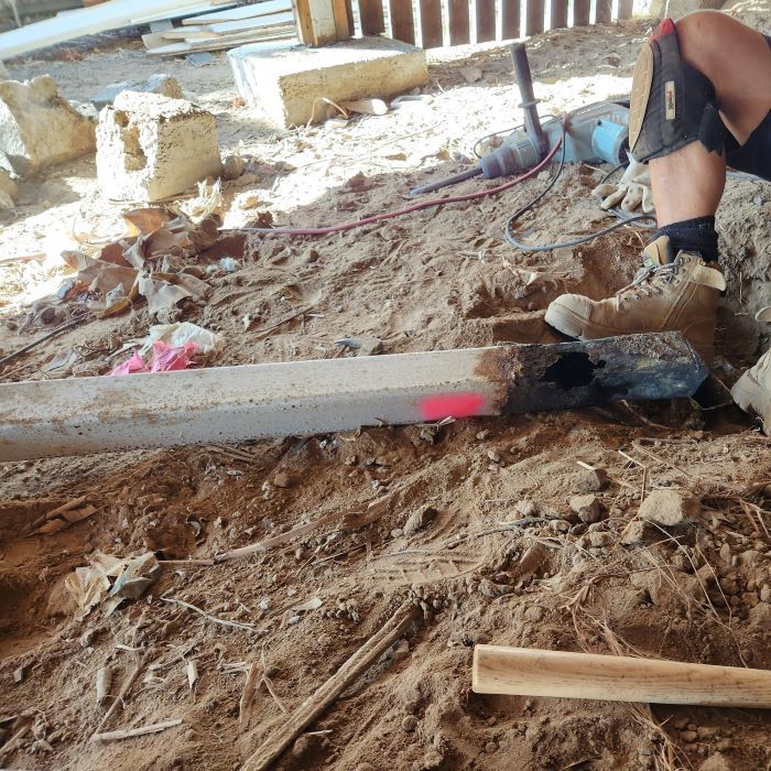 A Person is Using a Hammer to Hammer a Piece of Wood — Pro-Jax Pty Ltd in Mackay, QLD
