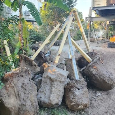 A Pile of Rocks Sitting on Top of a Dirt Field Next to a Wooden Structure — Pro-Jax Pty Ltd in Ayr, QLD