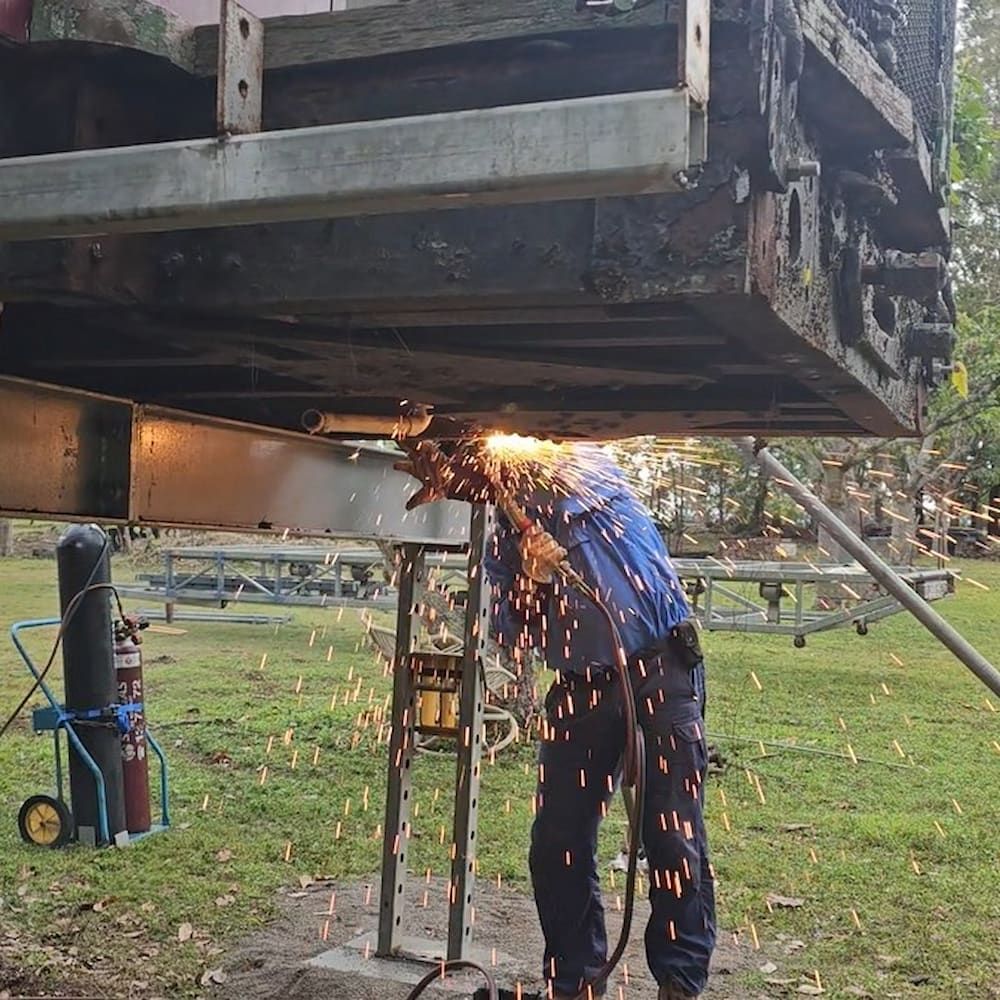 Welder Working on Metal Frame Outdoors, Sparks Flying — Pro-Jax Pty Ltd in Mackay, QLD