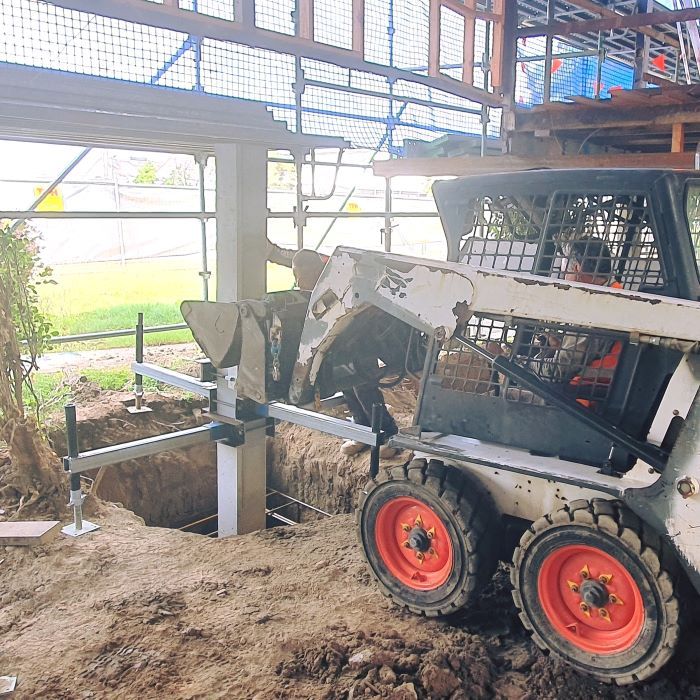 A Bobcat is Digging a Hole in the Ground — Pro-Jax Pty Ltd in Bohle, QLD
