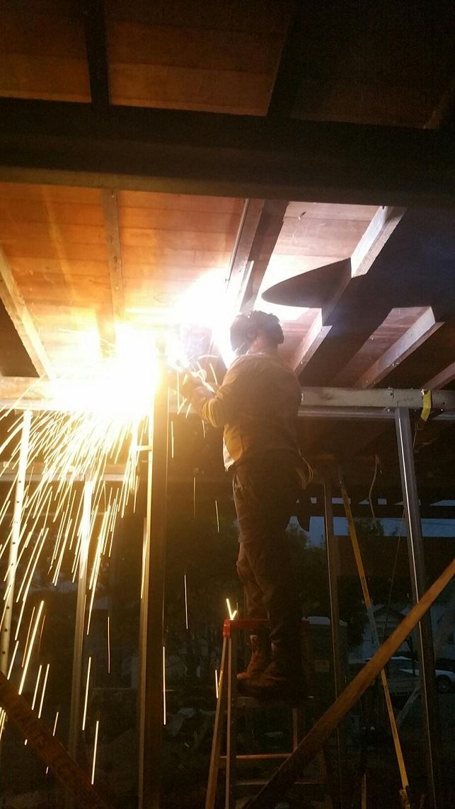 A Man is Welding a Piece of Wood in a Dark Room  — Pro-Jax Pty Ltd in Julia Creek, QLD