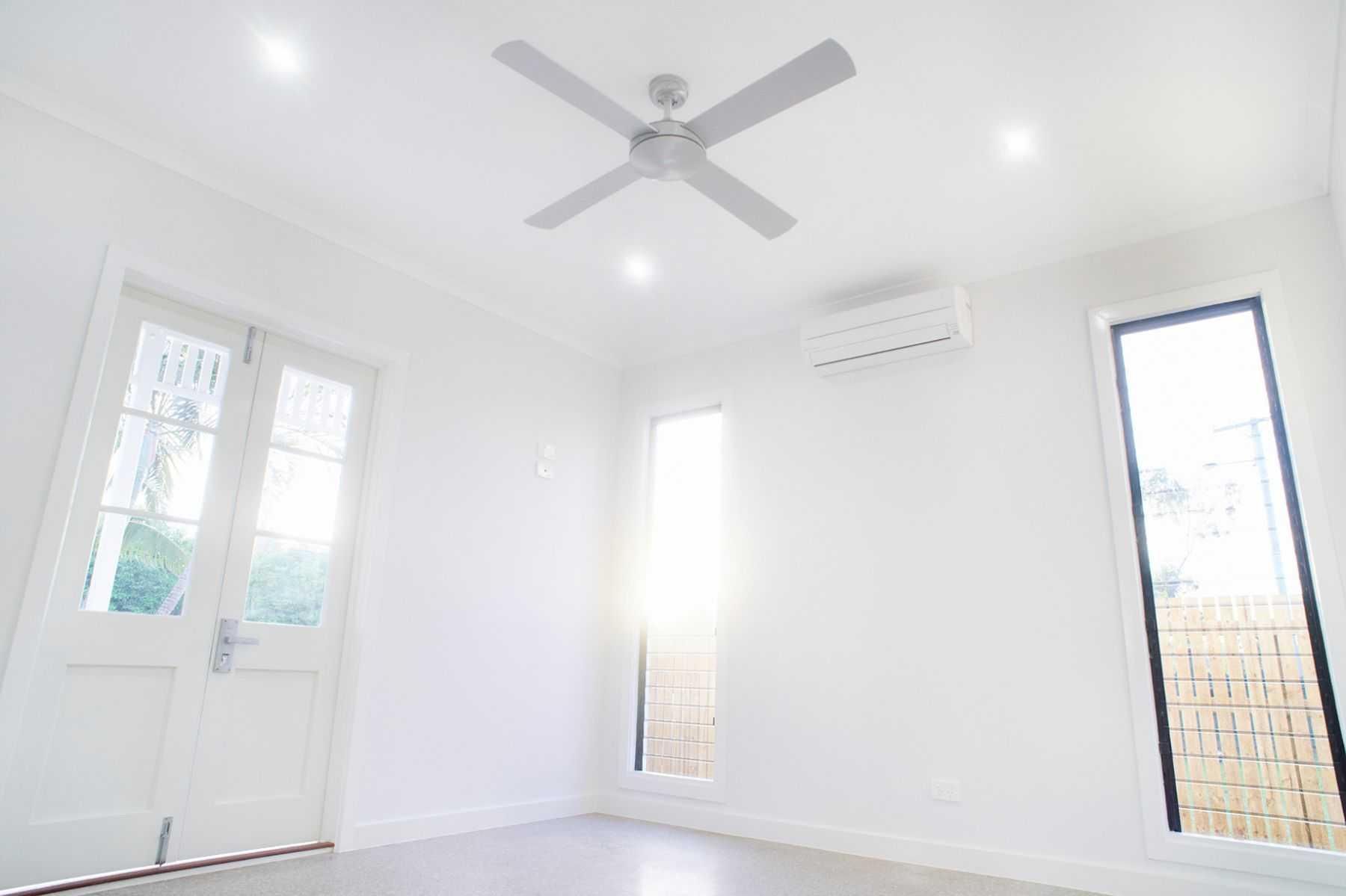 An Empty Room With a Ceiling Fan and Two Windows — Pro-Jax Pty Ltd in Bohle, QLD