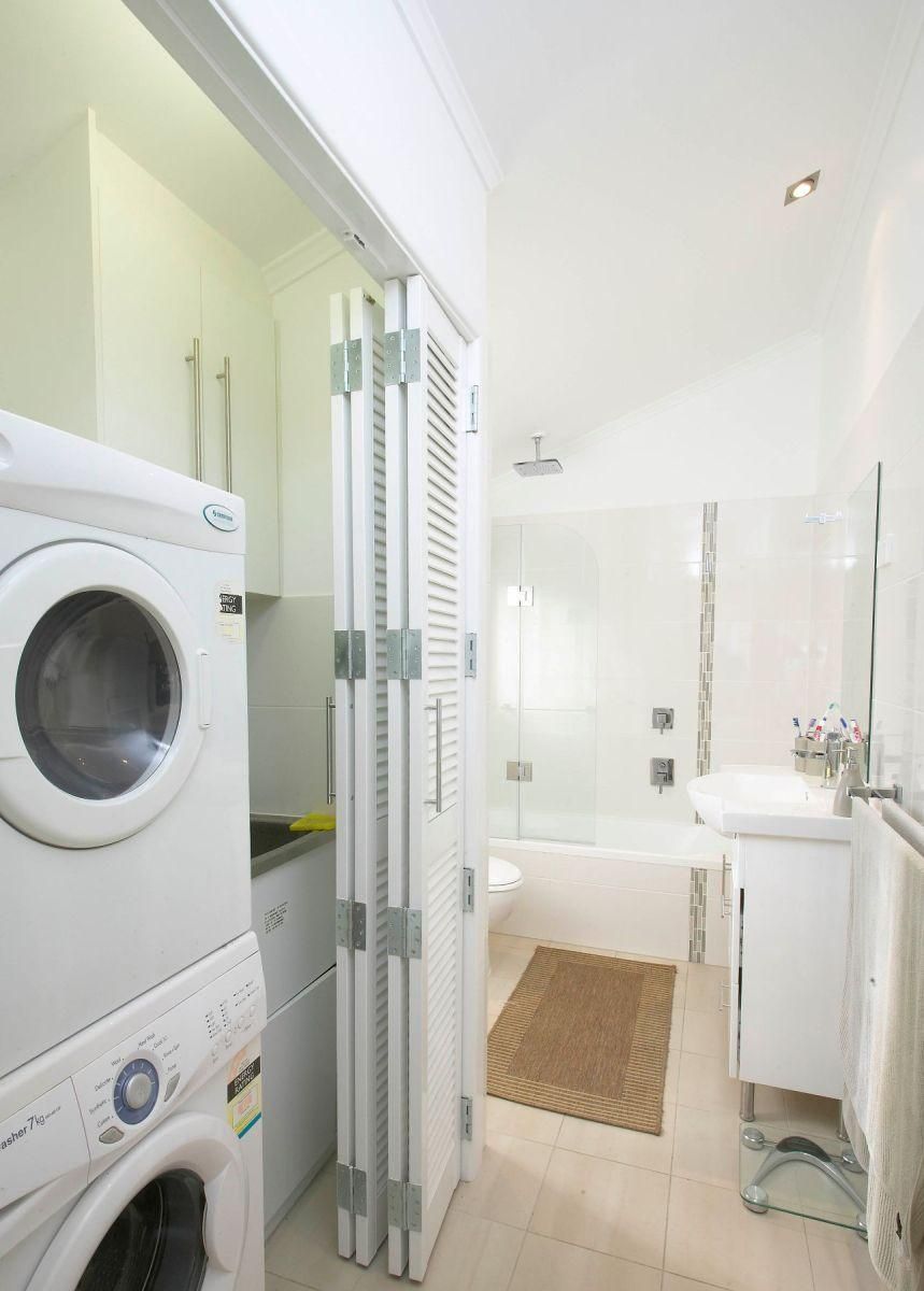 A Bathroom With a Washer and Dryer Stacked on Top of Each Other — Pro-Jax Pty Ltd in Bohle, QLD