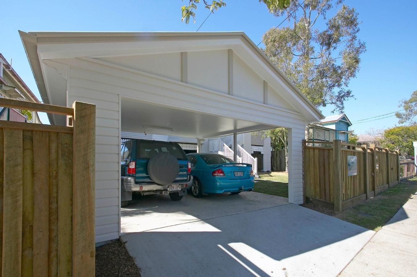 Two Cars Are Parked Under a Carport in Front of a House — Pro-Jax Pty Ltd in Bohle, QLD