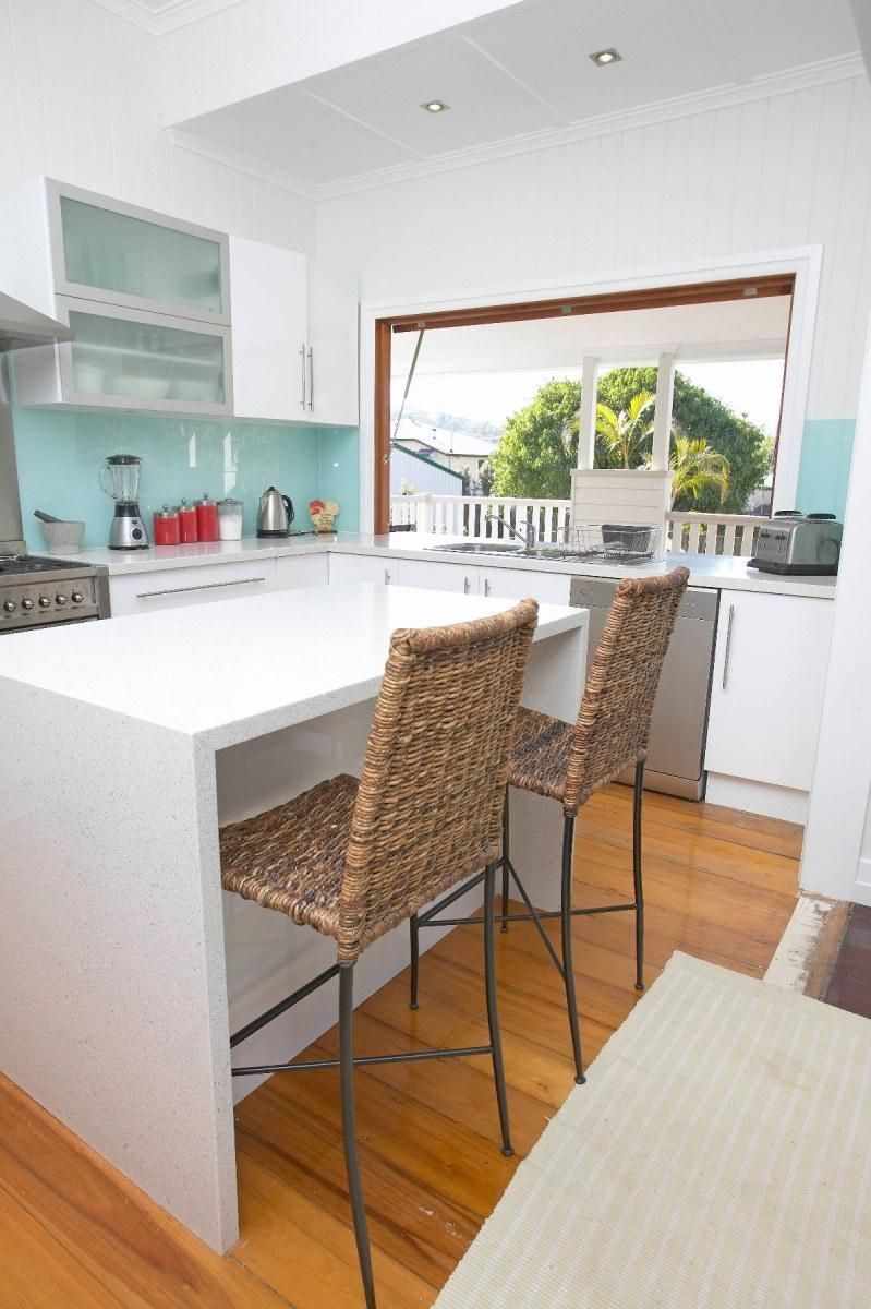 A Kitchen With White Cabinets and Wicker Chairs — Pro-Jax Pty Ltd in Bohle, QLD