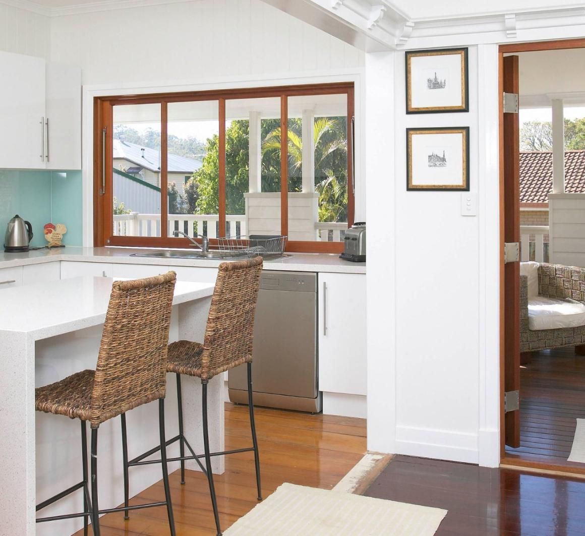 A Kitchen With Wicker Chairs and a Large Window — Pro-Jax Pty Ltd in Bohle, QLD
