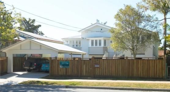 A White House With a Wooden Fence Around It — Pro-Jax Pty Ltd in Bohle, QLD