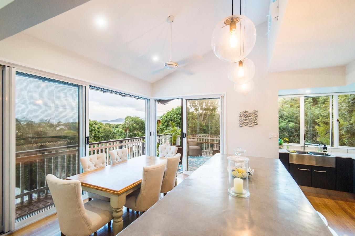 A Dining Room With a Table and Chairs and a Kitchen With Sliding Glass Doors — Pro-Jax Pty Ltd in Bohle, QLD