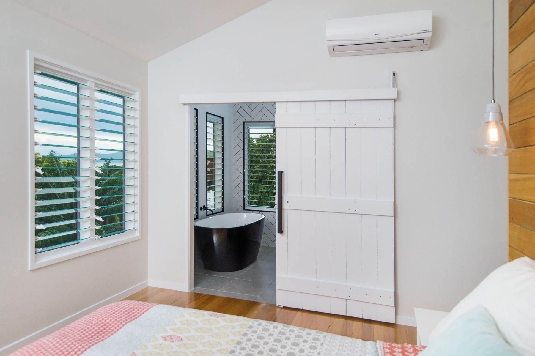 A Bedroom With a Sliding Barn Door Leading to a Bathroom — Pro-Jax Pty Ltd in Bohle, QLD