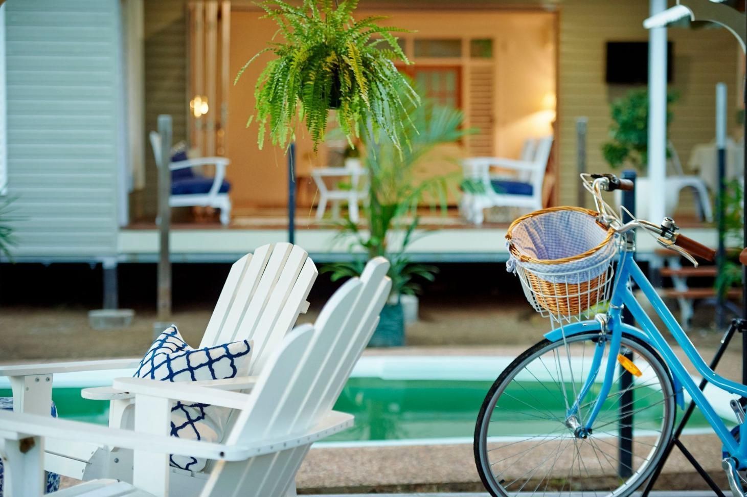 A Blue Bicycle is Parked Next to Two White Chairs in Front of a House — Pro-Jax Pty Ltd in Bohle, QLD