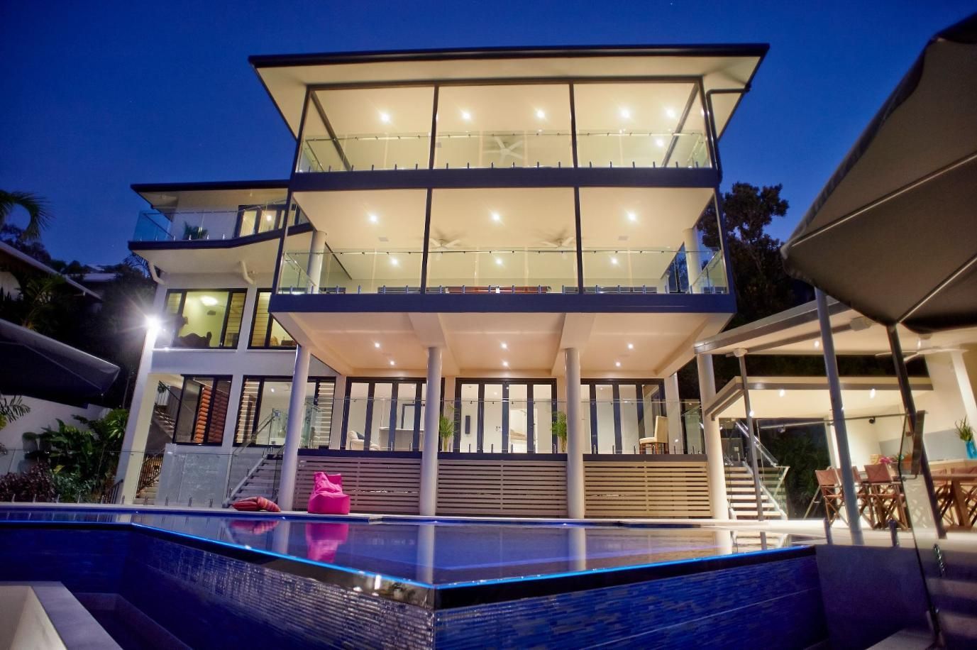 A Large House With a Swimming Pool in Front of It at Night — Pro-Jax Pty Ltd in Bohle, QLD