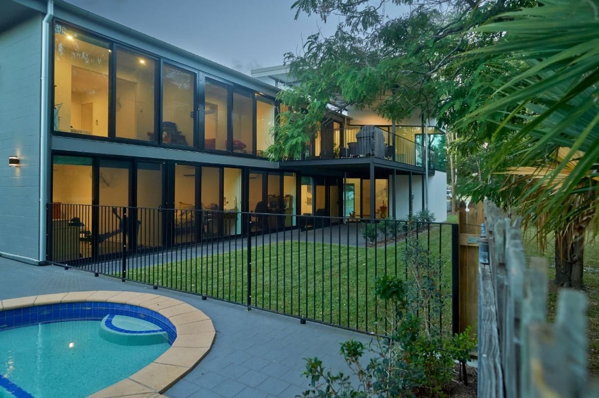 A Large House With a Swimming Pool in Front of It — Pro-Jax Pty Ltd in Bohle, QLD