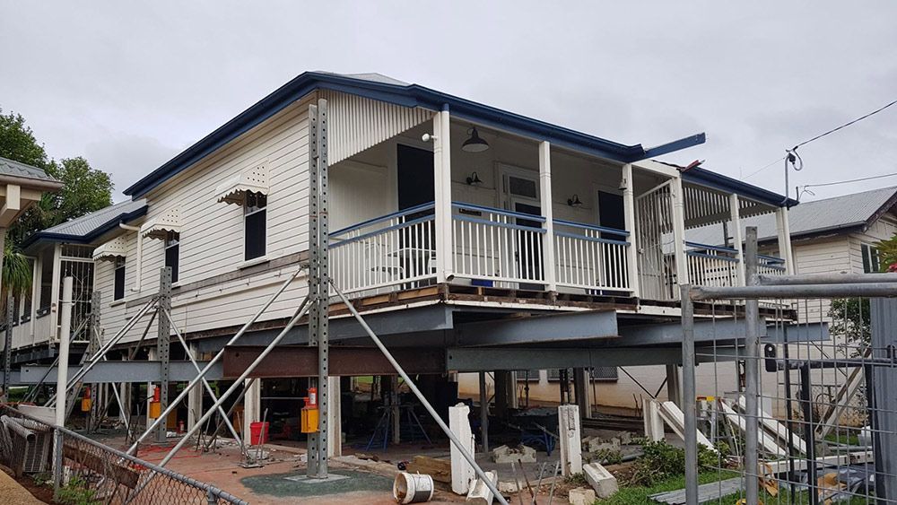 A Two-story White House is Elevated by Steel Beams and Scaffolding — Pro-Jax Pty Ltd in Bohle, QLD