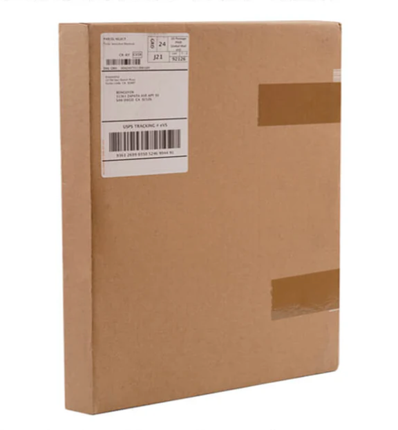 Plain brown cardboard shipping box with a white label and barcodes.