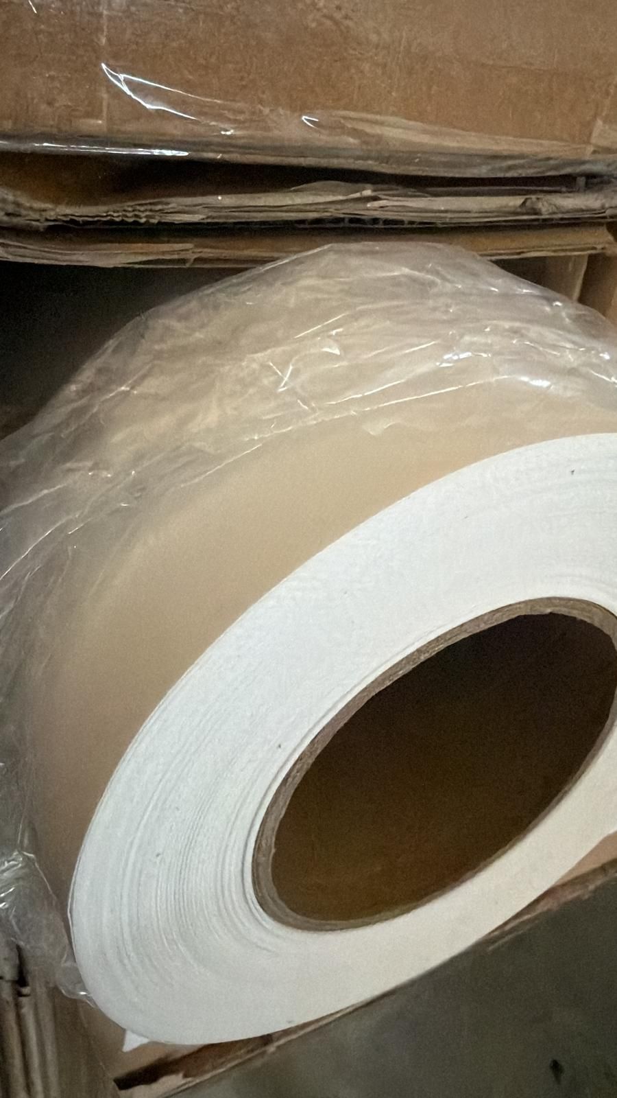 White roll of material in a cardboard box wrapped in plastic