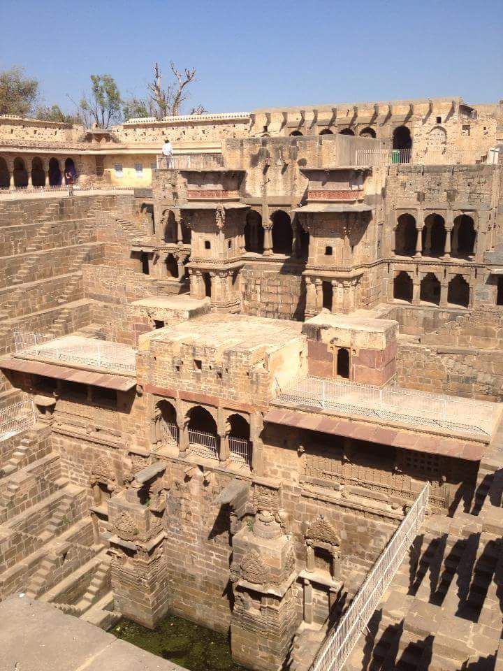Chand Baori in Rajasthan, India, featuring symmetrical stone steps descending into a deep, ancient stepwell.