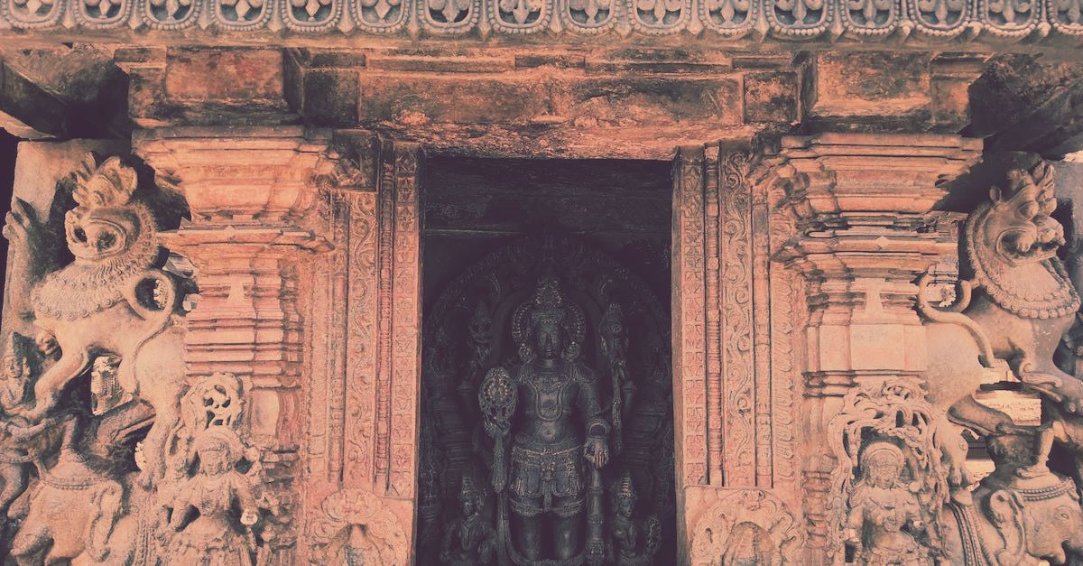 Intricately carved stone temple doorway featuring two large mythical creatures flanking a central inner deity statue.