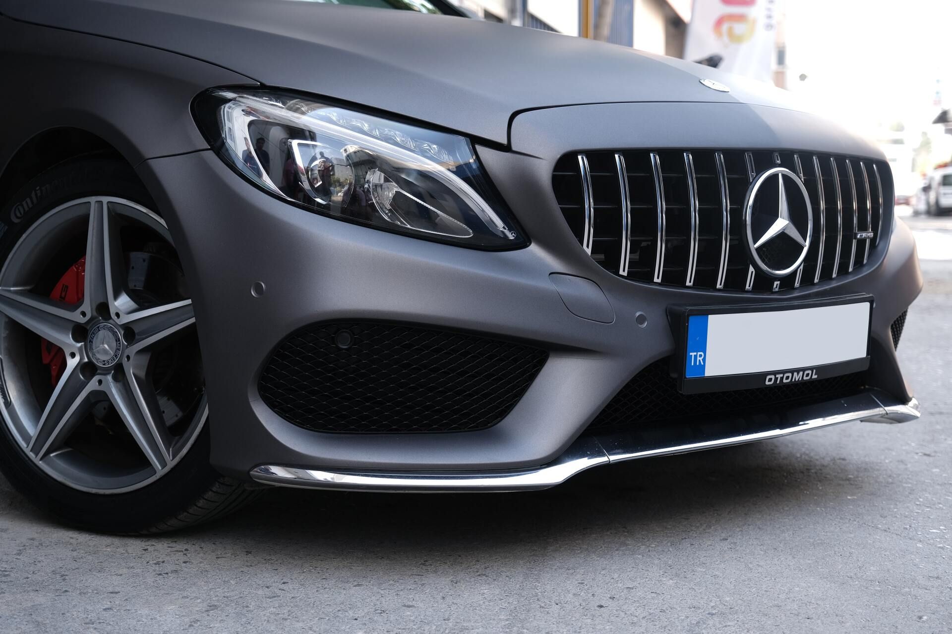 Front view of a matte gray Mercedes sports car parked on a street