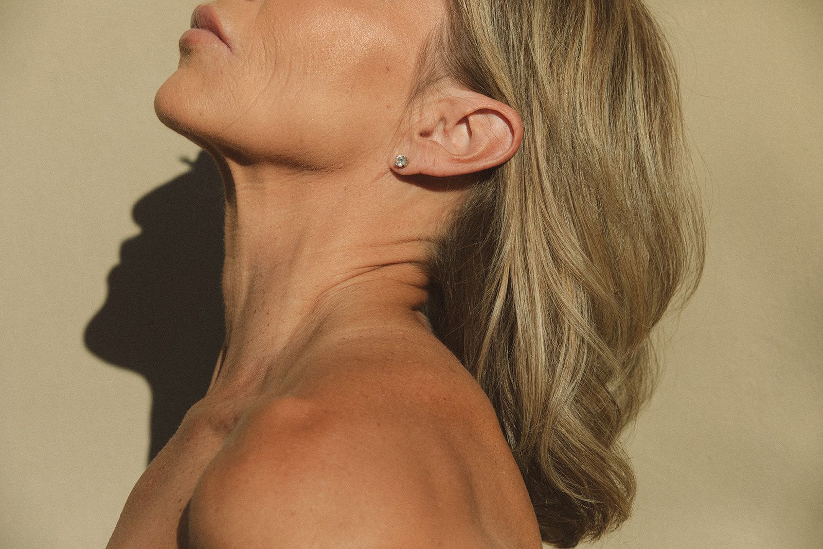 A woman without a shirt is looking up at the sky.