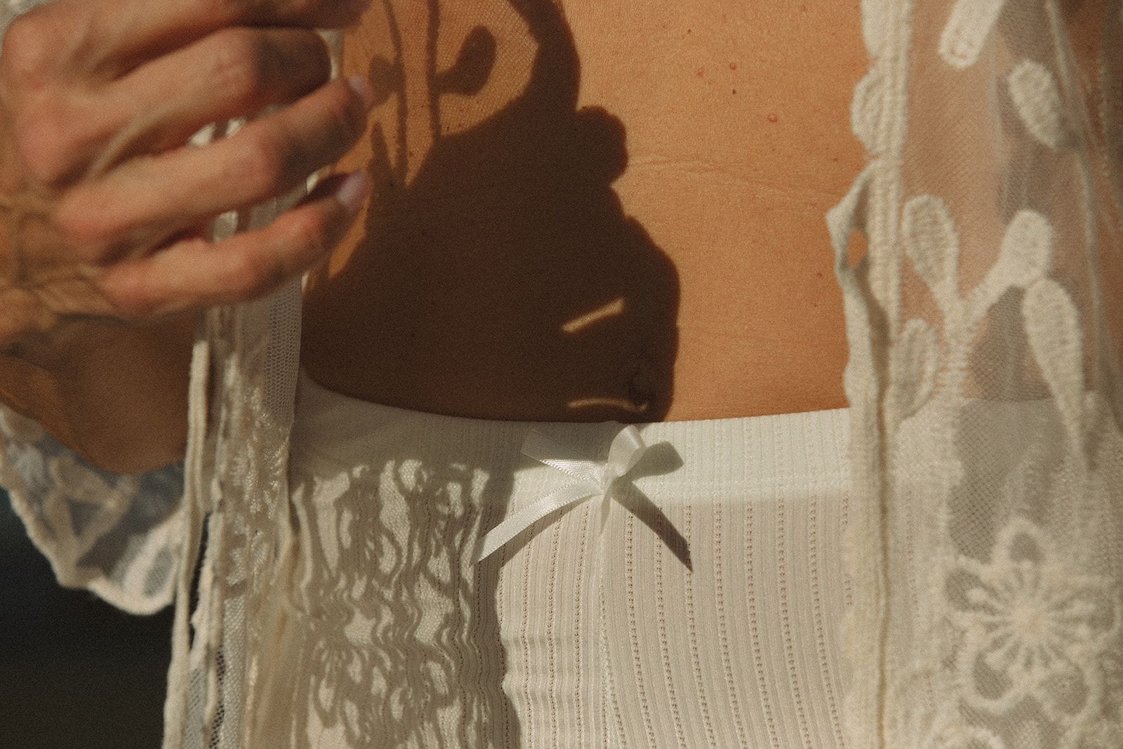 A woman in a white dress is holding a glass of wine.