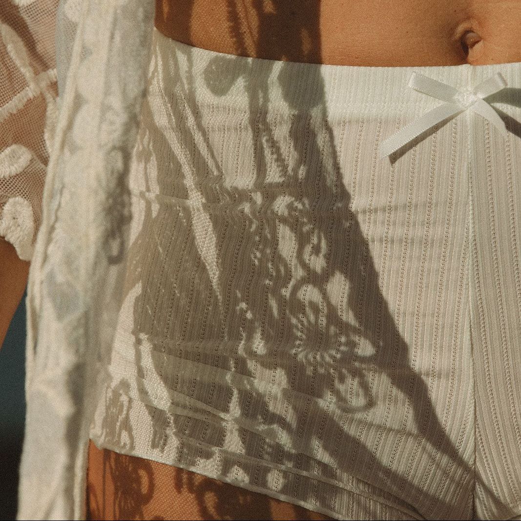 A close up of a woman 's stomach with a shadow of a tree on it.