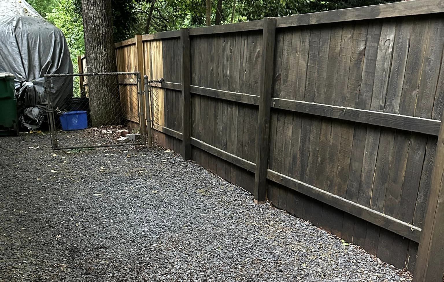 yard waste removed from beside wooden fence