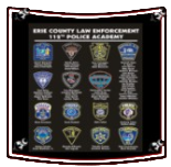 Wall display of Erie County law enforcement and police academy patches on a black background.