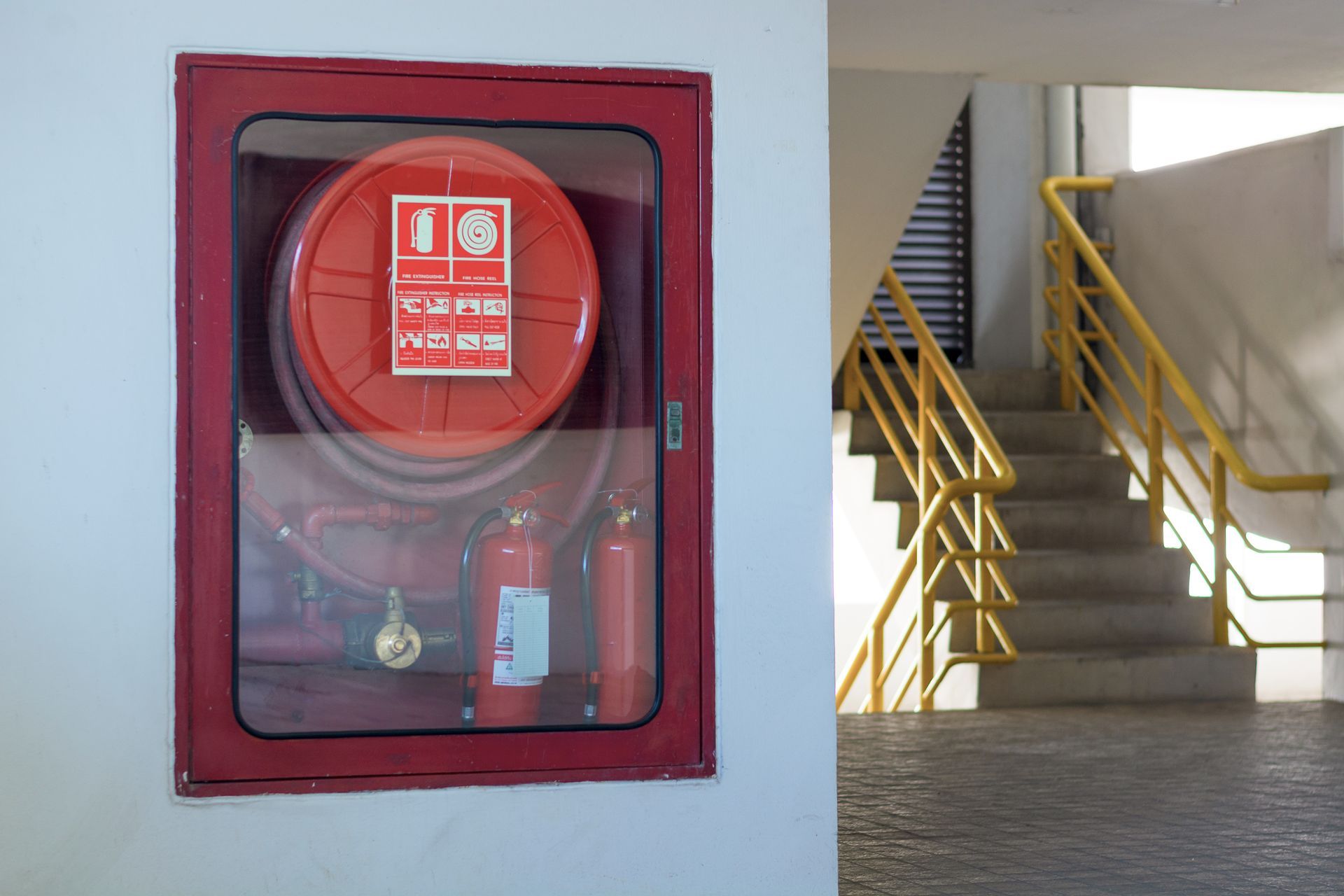 Fire extinguisher cabinet and equipment are in the hallway to prevent fire emergencies.