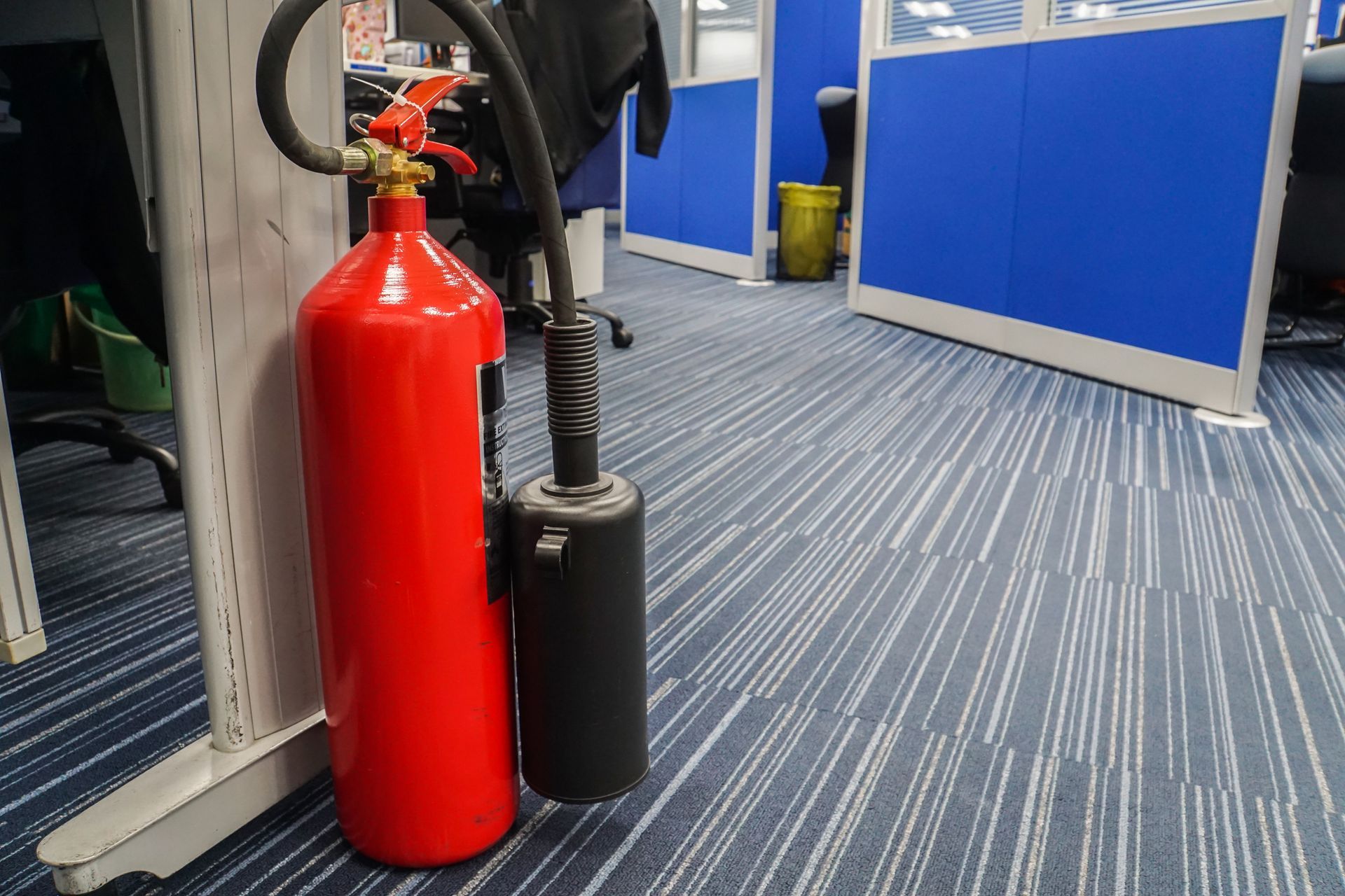 Red fire extinguisher in office, showcasing fire extinguisher refilling for workplace safety.