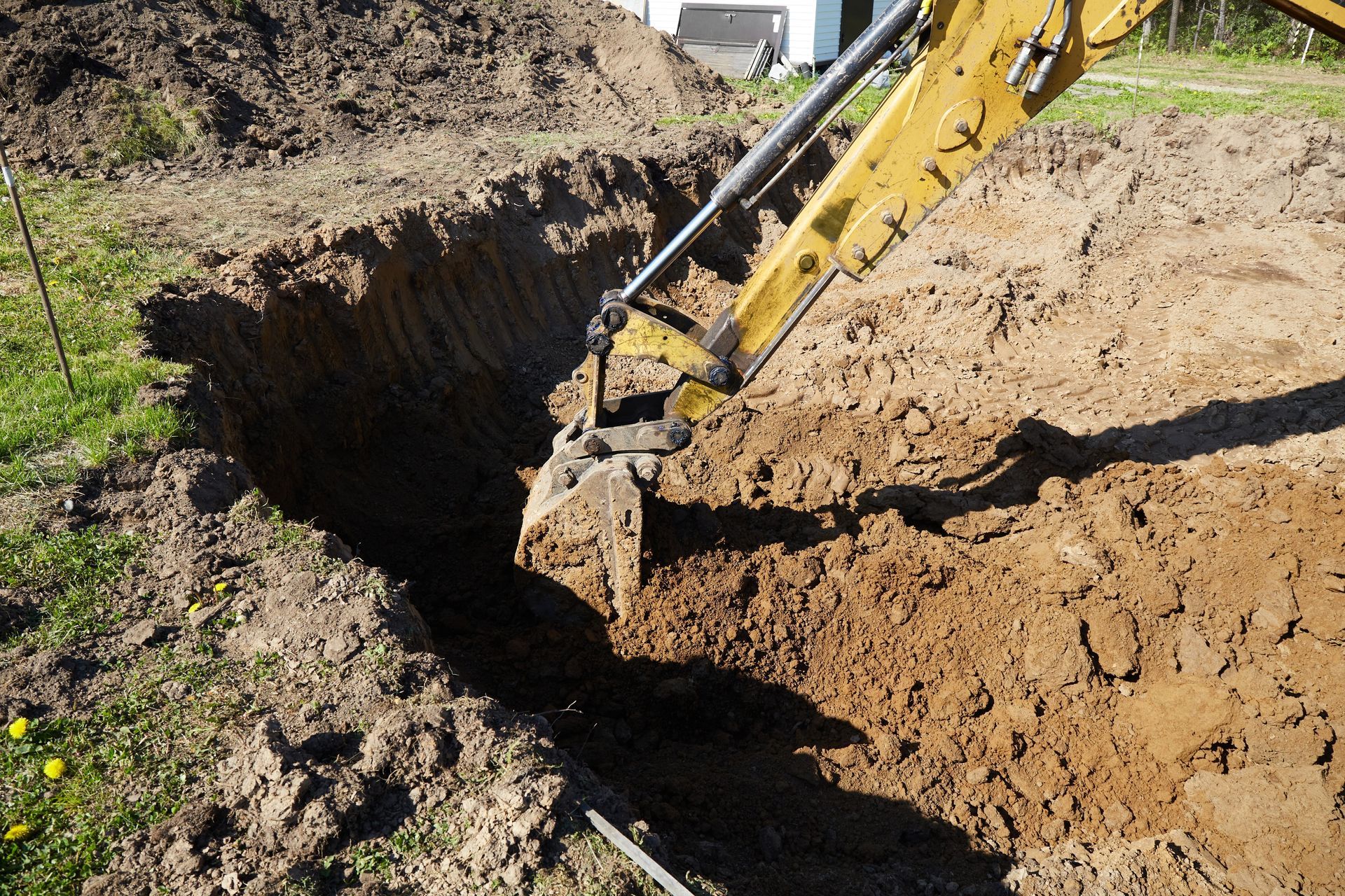 Excavator digging a trench in a dirt construction site