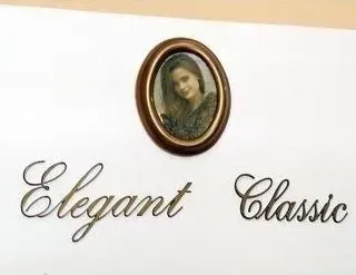 Elegante insegna da parete in stile classico con scritta in corsivo e piccolo ritratto ovale in cornice marrone.