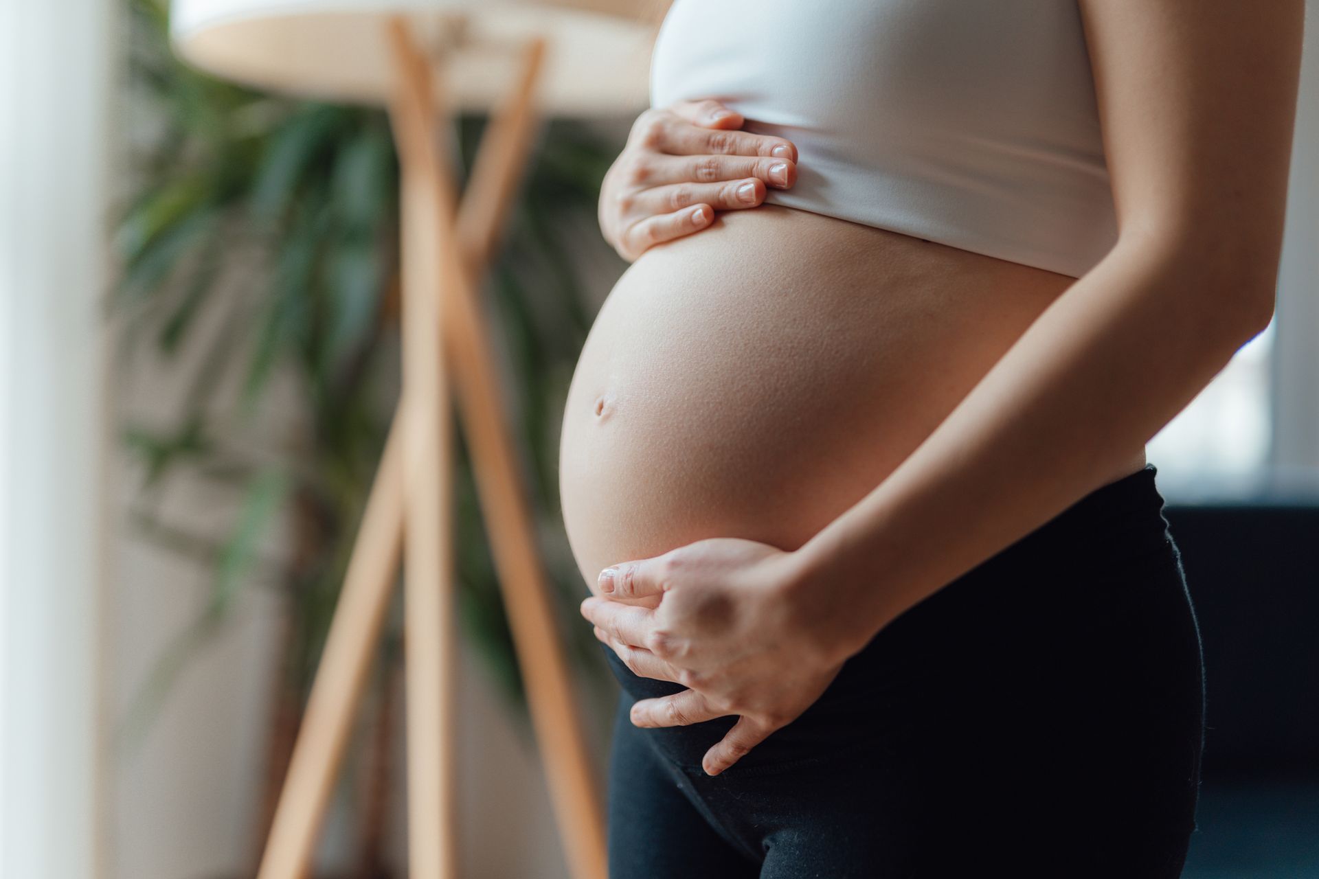 Pregnant Person Holds Their Rounded Belly — Gowen, MI — RiverSong Midwifery