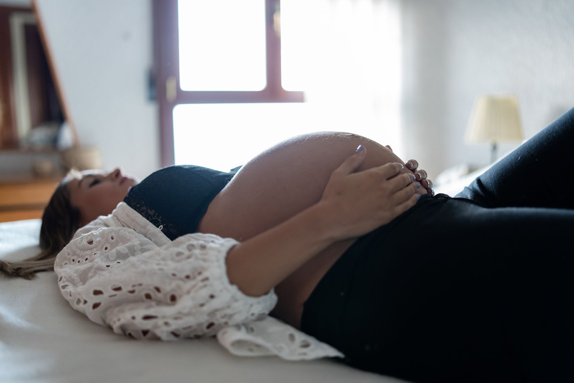 Pregnant Woman Lying on A Bed — Gowen, MI — RiverSong Midwifery