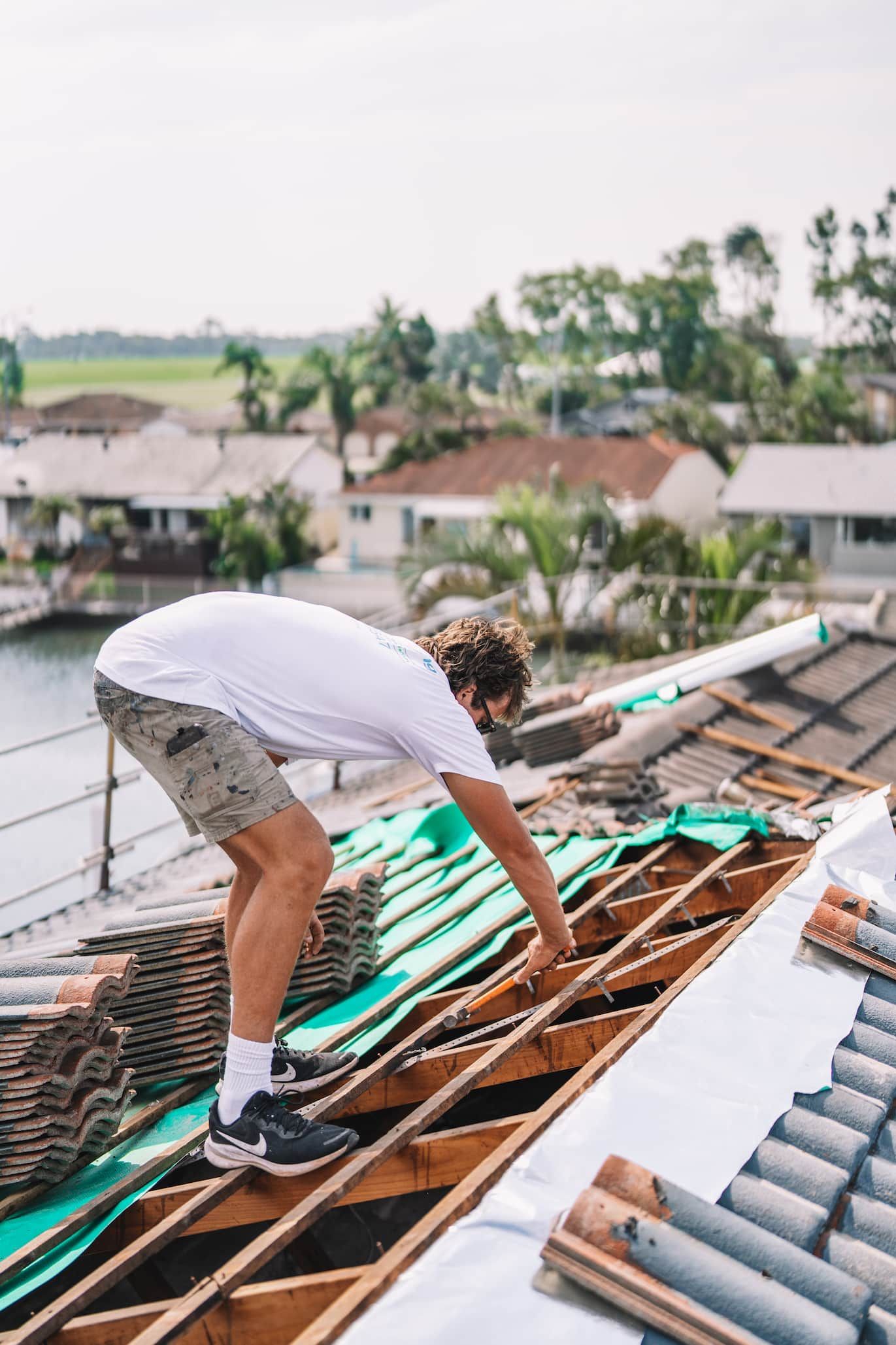 A man is working on the roof of a house.
