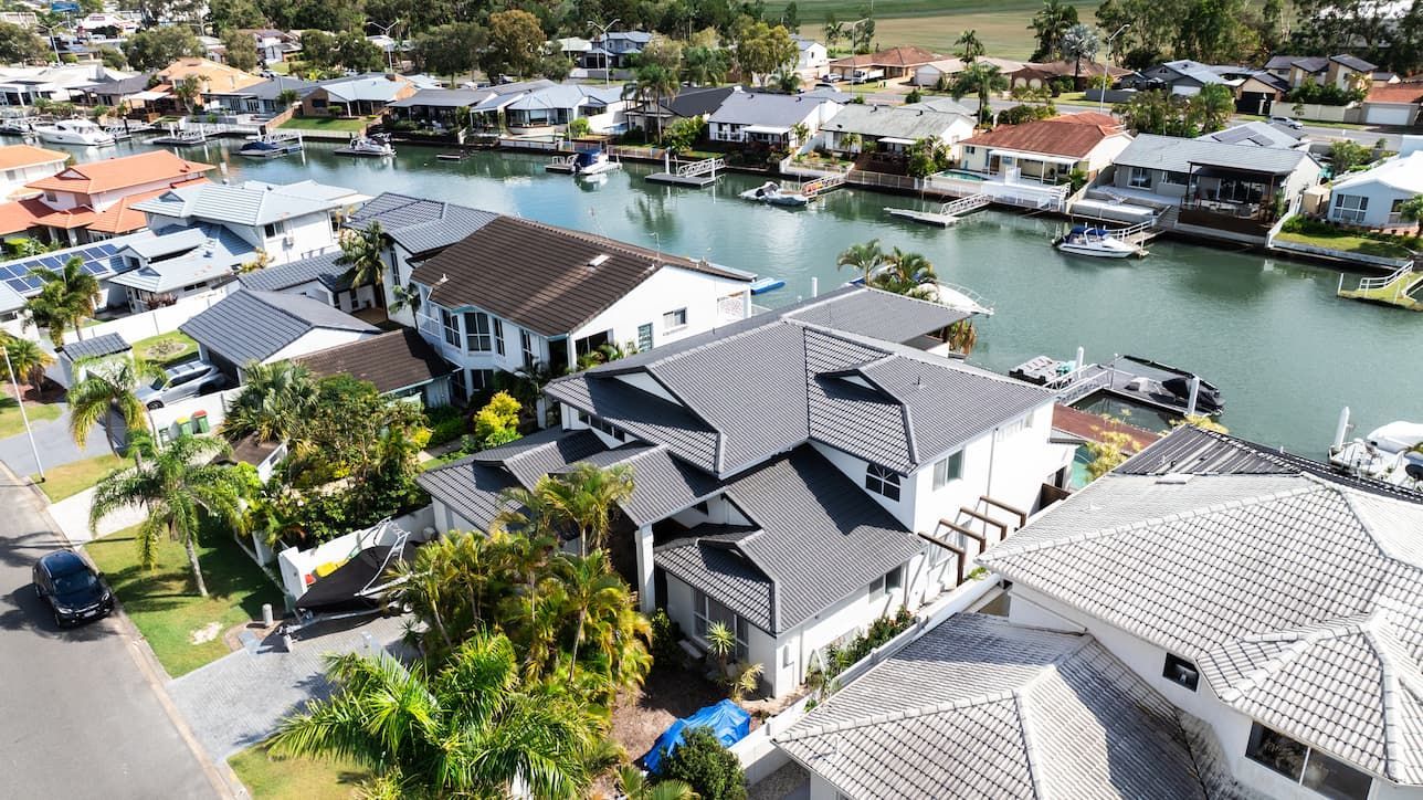 An aerial view of a residential area with a body of water in the background.