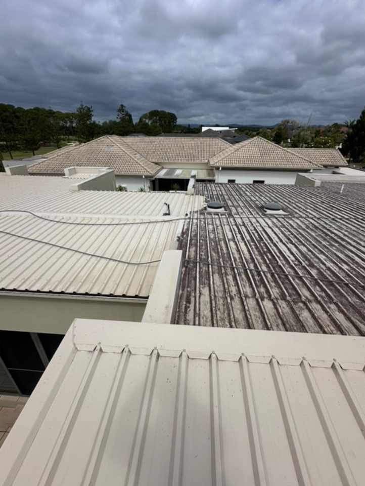 An aerial view of a roof of a building with a cloudy sky in the background.