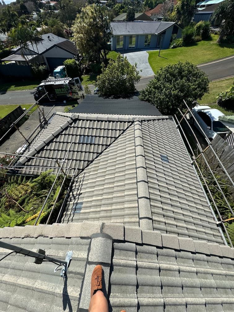 A person is standing on the roof of a house.